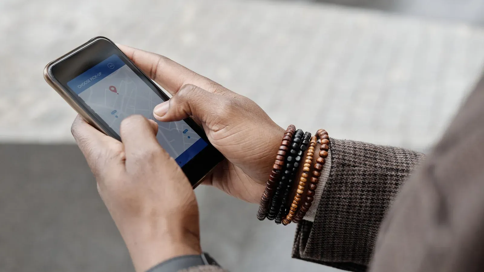 Pessoa olhando o smartphone na porta do próprio negócio, com o Google Maps aberto mostrando o perfil da empresa e avaliações.