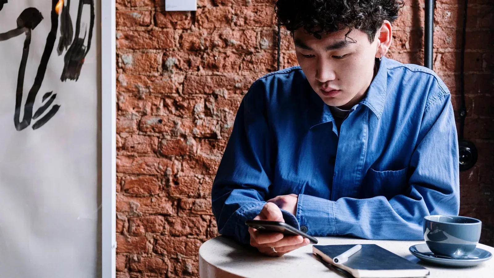 Dono de loja atendendo mensagens de WhatsApp no celular atrás do balcão